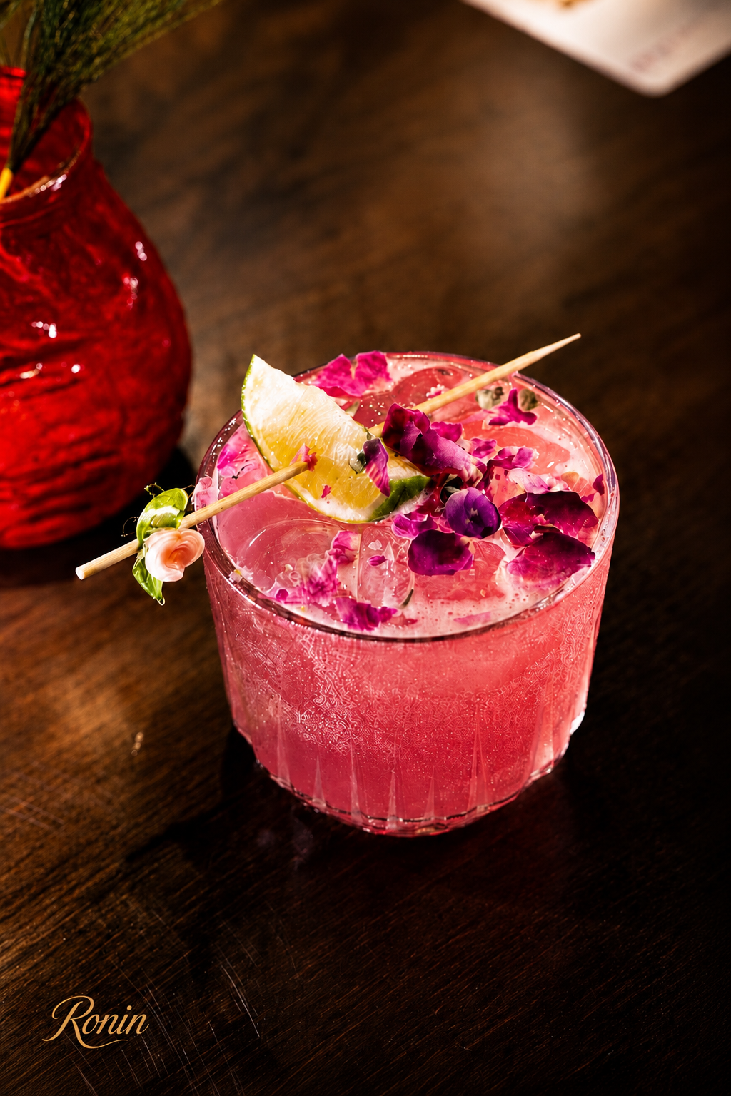 Pink Ronin signature cocktail with rose petals and lime