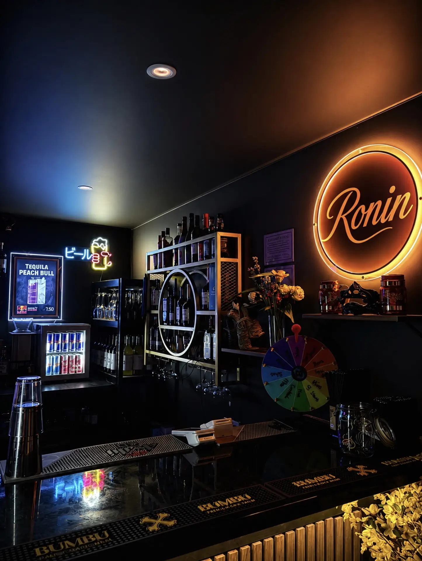 The Ronin bar counter glowing under neon signs